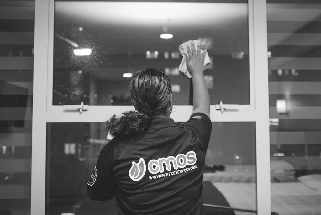 A CMOS team member cleaning a window