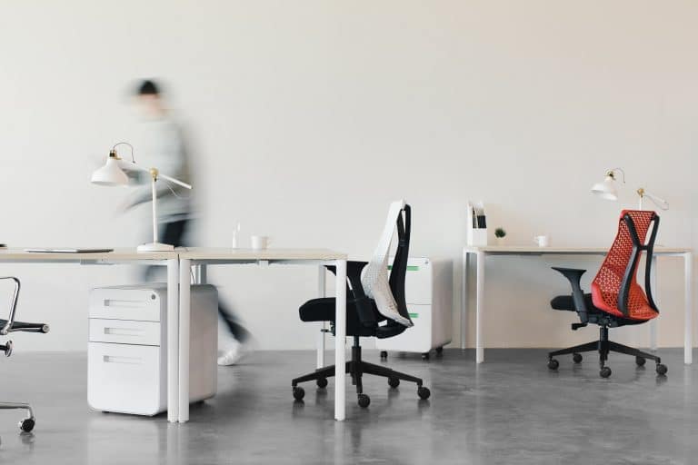 Person walking quickly past desks